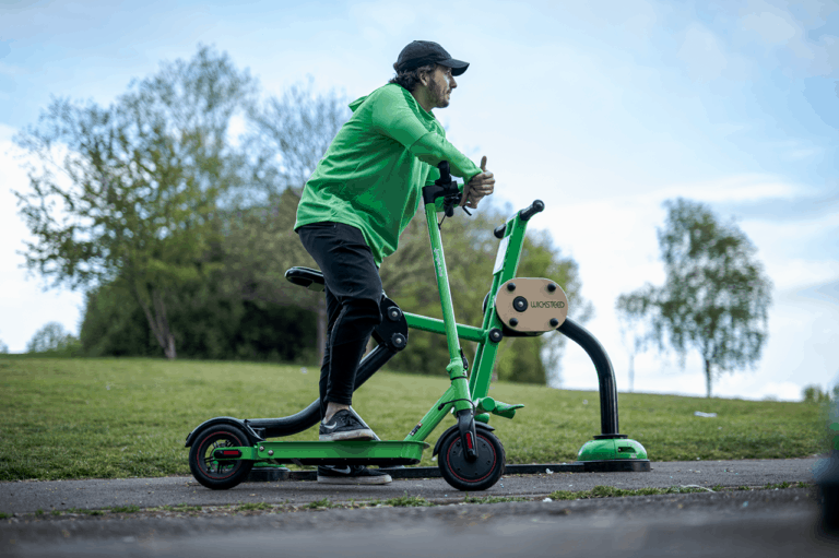 man riding green electric scooter in park